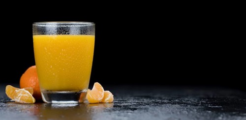 Fresh made Tangerine Juice on a vintage slate slab (selective focus)