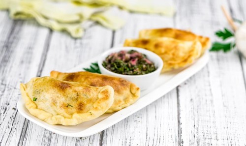 Portion of healthy Empanadas on an old wooden table (selective focus, close-up shot)