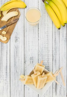 Homemade Banana Popsicles on a vintage background (close-up shot, selective focus)