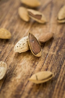 Roasted and salted Almonds (with shell) on a vintage background (close-up shot)