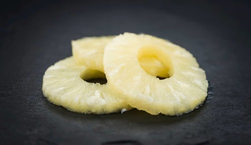 Some fresh Preserved Pineapple Rings on a vintage slate slab, selective focus, close-up shot