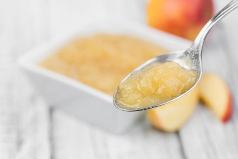 Portion of homemade Applesauce (selective focus, close-up shot) on vintage background