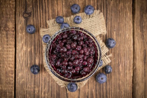 Homemade Preserved Blueberries on an wooden table as detailed close-up shot, selective focus