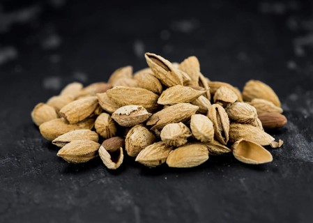 Almonds in shell (roasted and salted) on a vintage background (close-up shot)