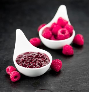 Portion of Raspberry Jam on a rustic slate slab, selective focus, close-up shot