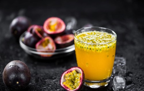 Portion of healthy Maracuja Juice on a slate slab (selective focus)