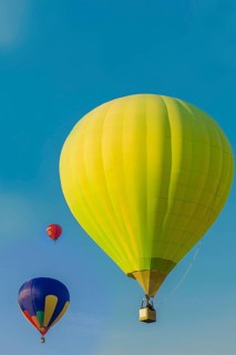 Three colorful hot air balloons floating in a clear blue sky, Belarus, Minsk, Europe