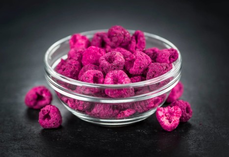 Portion of Dried Raspberries as detailed close up shot on a slate slab, selective focus