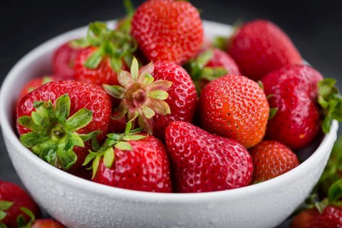 Portion of Strawberries as detailed close up shot on a slate slab, selective focus
