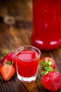 Fresh made Strawberry liqueur on an old and rustic wooden table, selective focus, close-up shot