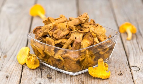 Canned chanterelles on a vintage background as detailed close-up shot, selective focus