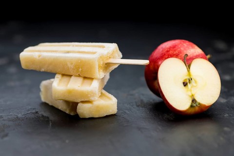 Portion of homemade Apple Popsicles (selective focus, close-up shot) on a vintage background