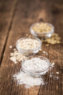 Vintage wooden table with Oat Flour (selective focus, close-up shot)