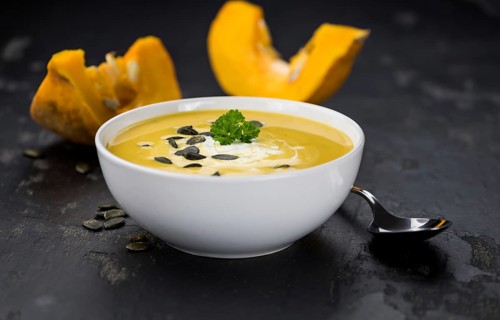 Fresh made Pumpkin Soup (close-up shot) on a vintage background (selective focus)