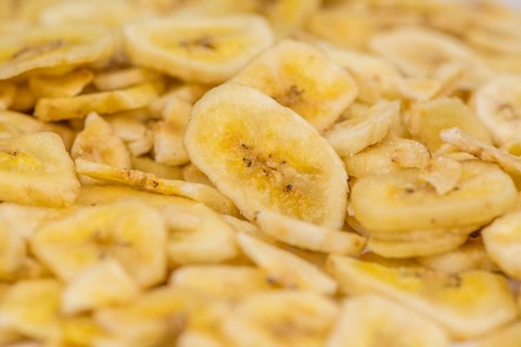 Fresh made Dried Banana Chips on an old and rustic wooden table, selective focus, close-up shot