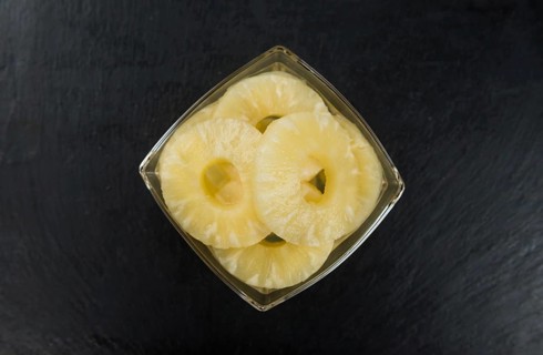 Preserved Pineapple Rings on a vintage slate slab as detailed close-up shot, selective focus