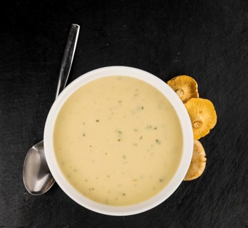 Portion of Chanterelle Soup on a rustic slate slab, selective focus, close-up shot