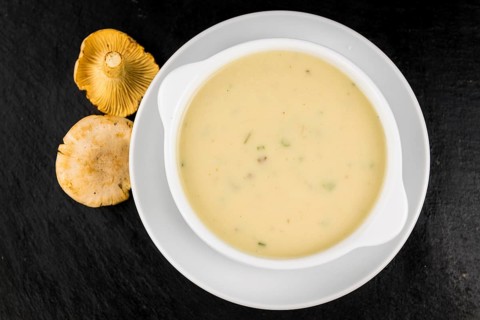 Some fresh Chanterelle Soup on a vintage slate slab, selective focus, close-up shot