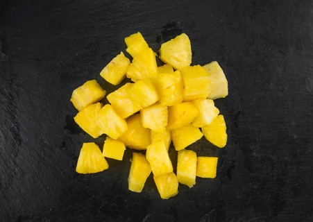 Portion of Pineapple (sliced) on a rustic slate slab, selective focus, close-up shot