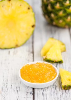 Pineapple Jam as high detailed close-up shot on a vintage wooden table, selective focus