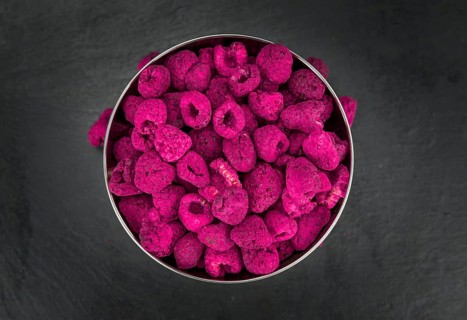 Dried Raspberries on a vintage slate slab as detailed close-up shot, selective focus
