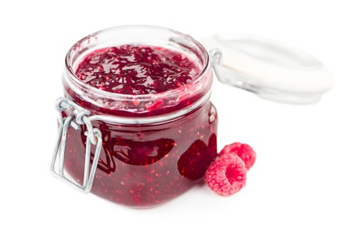 Fresh made Raspberry Jam isolated on white background, close-up shot
