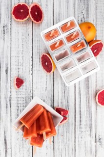 Some freshly made Grapefruit Popsicles (with some fresh fruits, selective focus)
