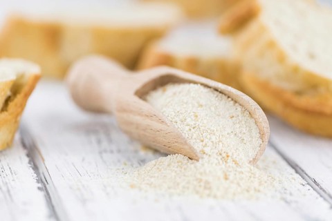 Old wooden table with fresh Breadcrumbs (close-up shot, selective focus)