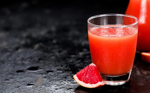 Slate slab with freshly squeezed Grapefruit Juice (selective focus, close-up shot)
