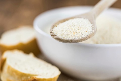 Some Bread Crumbs on a vintage wooden table (selective focus, close-up shot)