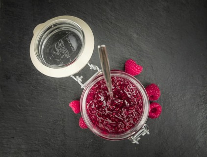 Portion of Raspberry Jam on a rustic slate slab, selective focus, close-up shot