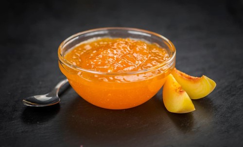 Portion of fresh Peach Jam close-up shot, selective focus