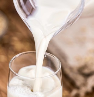 Wooden table with Oat Milk (detailed close-up shot, selective focus)