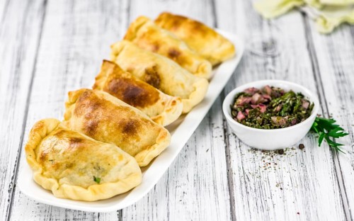 Portion of healthy Empanadas on an old wooden table (selective focus, close-up shot)