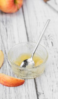 Homemade Applesauce (selective focus, close-up shot) on vintage background with some fresh fruits