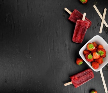 Strawberry Popsicles (close-up shot, selective focus) on a rustic background
