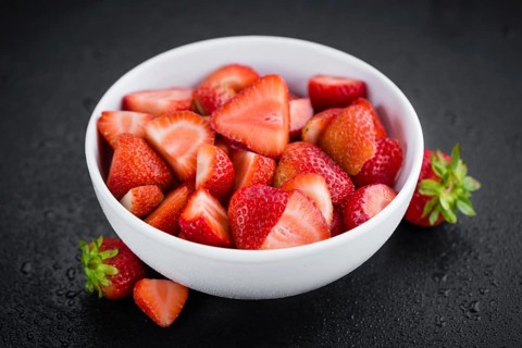 Sliced Strawberries on a vintage slate slab as detailed close-up shot, selective focus