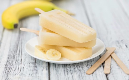 Banana Popsicles (on wooden background) as detailed close-up shot