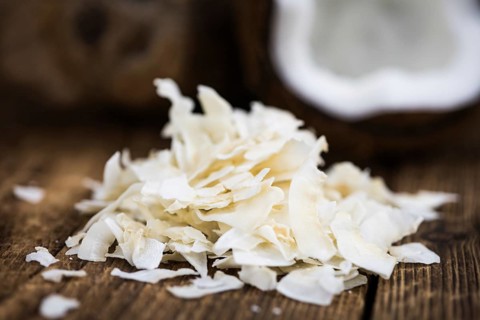 Coconut Chips (fresh) as detailed close-up shot, selective focus)