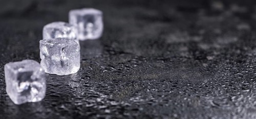 Some melting Ice cubes on a vintage slate slab (selective focus)