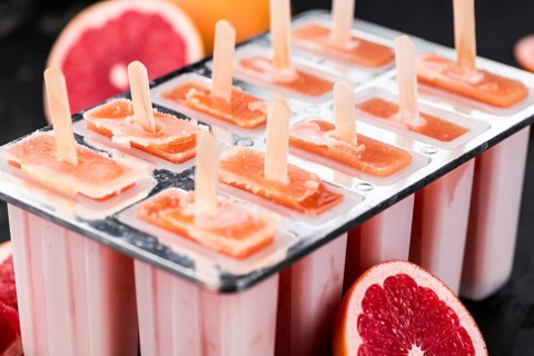 Vintage slate slab with some freshly made Grapefruit Popsicles (selective focus, close-up shot)
