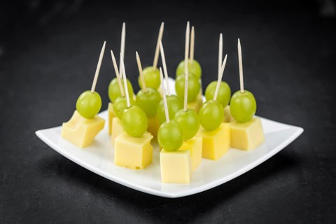 Cheese blocks with grapes as close-up shot (selective focus, partyfood)
