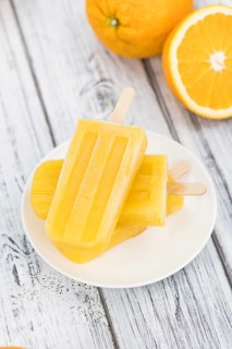 Some fresh made Popsicles (close-up shot, selective focus) on a wooden background