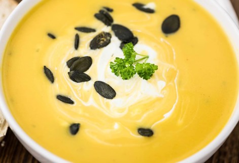 Fresh made Pumpkin Soup (close-up shot) on a vintage background (selective focus)