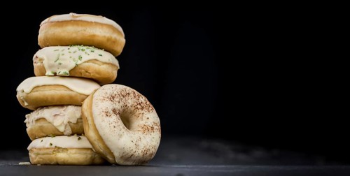 Some fresh made white chocolate Donuts (selective focus, close-up shot)