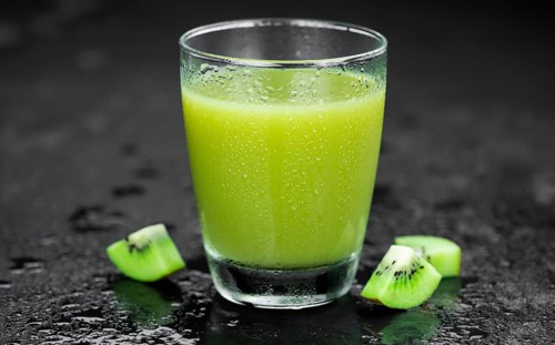 Some fresh homemade Kiwi Smoothies on a slate slab (close-up shot, selective focus)