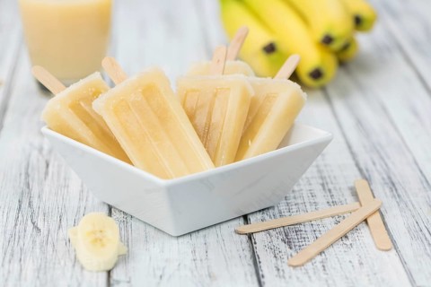 Banana Popsicles (on wooden background) as detailed close-up shot