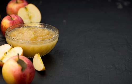 Homemade Applesauce (selective focus, close-up shot) on vintage background with some fresh fruits