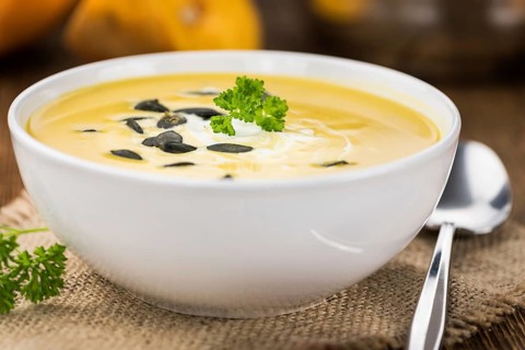 Fresh made Pumpkin Soup (close-up shot) on a vintage background (selective focus)