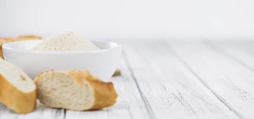 Old wooden table with fresh Breadcrumbs (close-up shot, selective focus)